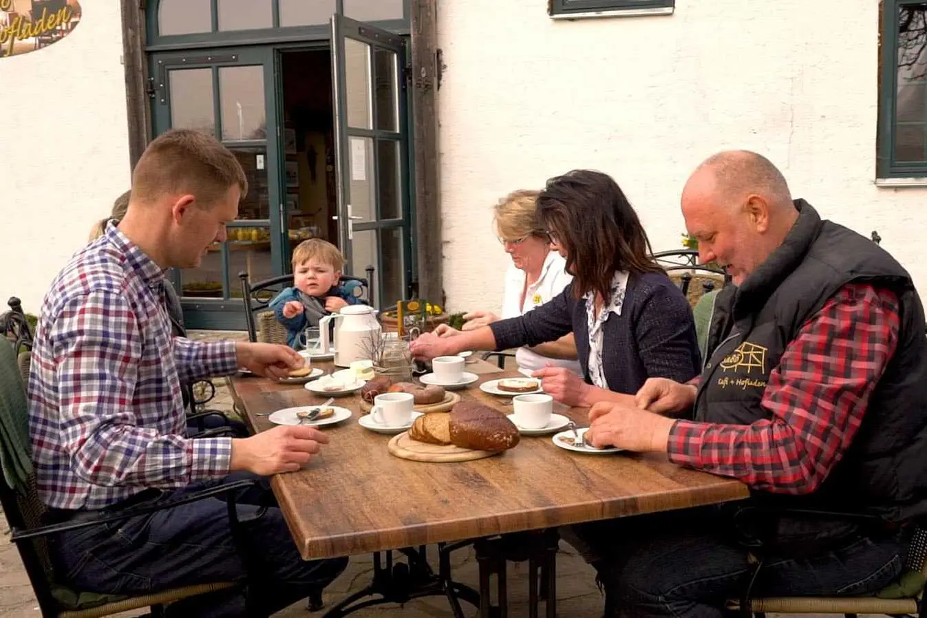Familie am Esstisch draußen